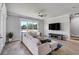 Bright living room featuring wood floors, plush seating, and a large window overlooking the landscaped yard at 655 Whisper Woods Dr, Lakeland, FL 33813