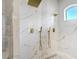 Luxurious walk-in shower featuring double shower heads, pebble floor, and marble-style walls at 655 Whisper Woods Dr, Lakeland, FL 33813