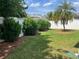 Serene backyard featuring lush green grass, mature trees, and a well-maintained privacy fence at 1087 Jackson St, The Villages, FL 32162