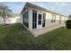 Backyard featuring a screened-in patio, well-maintained lawn, and partial view of the surrounding fence at 1087 Jackson St, The Villages, FL 32162