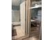 View of a bedroom featuring two twin beds, ceiling fan, and tiled flooring, transitioning to a bathroom with shower at 1087 Jackson St, The Villages, FL 32162