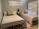 Charming bedroom featuring twin beds, coastal decor, and natural light from the window at 1087 Jackson St, The Villages, FL 32162