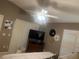 Bedroom with blinds, ceiling fan and television; neutral colored walls provide a calming atmosphere at 1087 Jackson St, The Villages, FL 32162