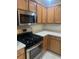 Well-lit kitchen boasts stainless steel appliances, sleek countertops, and wood cabinetry at 1087 Jackson St, The Villages, FL 32162