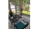 Inviting screened lanai with a metal table, two chairs, and a view of the beautifully landscaped yard at 1087 Jackson St, The Villages, FL 32162