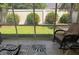 Relaxing screened lanai featuring a cozy armchair, lush backyard view, and tranquil ambiance at 1087 Jackson St, The Villages, FL 32162