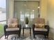 Relaxing screened lanai with wicker chairs, decorative pillows, and a serene backyard view at 1087 Jackson St, The Villages, FL 32162