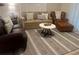 Inviting living room featuring neutral furniture, decorative rug, and plantation shutters for a cozy atmosphere at 1087 Jackson St, The Villages, FL 32162