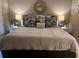 Well-lit primary bedroom featuring a king bed, symmetrical nightstands, modern lamps, and elegant decor at 1087 Jackson St, The Villages, FL 32162