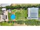 Aerial view of well-maintained backyard with lush lawn, landscaping, and inviting blue swimming pool at 1395 S Lake Reedy Blvd, Frostproof, FL 33843