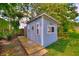 Charming blue shed with a wooden ramp and a garden with lush vegetation at 1395 S Lake Reedy Blvd, Frostproof, FL 33843