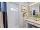 Stylish bathroom featuring a tiled shower and vanity with a framed mirror and beach themed decor at 1395 S Lake Reedy Blvd, Frostproof, FL 33843
