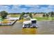 Exterior view of a boat dock with lifts on a waterfront property with multiple structures at 1395 S Lake Reedy Blvd, Frostproof, FL 33843