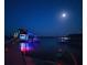 Night view of a dock with a covered seating area lit with colorful lights under a full moon at 1395 S Lake Reedy Blvd, Frostproof, FL 33843