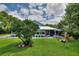 A beautifully landscaped backyard features a screened-in porch, a patio deck, and lush green grass at 1395 S Lake Reedy Blvd, Frostproof, FL 33843