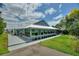 Exterior home view featuring a long screened-in porch with a deck and beautifully landscaped yard at 1395 S Lake Reedy Blvd, Frostproof, FL 33843