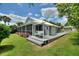 A spacious wooden patio deck with a porch swing connects to a screened-in porch, adding outdoor living space at 1395 S Lake Reedy Blvd, Frostproof, FL 33843