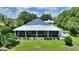 Charming screened porch overlooks the lush backyard with mature landscaping and a metal roof at 1395 S Lake Reedy Blvd, Frostproof, FL 33843