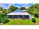 Charming home featuring a metal roof, spacious screened porch, and well-manicured lawn at 1395 S Lake Reedy Blvd, Frostproof, FL 33843