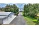 Aerial view of a home with a detached four-car garage with mature trees lining the driveway at 1395 S Lake Reedy Blvd, Frostproof, FL 33843