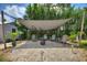 Backyard fire pit area features Adirondack chairs, landscaping, and shade at 1395 S Lake Reedy Blvd, Frostproof, FL 33843