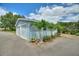 A garage with white doors and light blue siding has small palm trees planted near the driveway at 1395 S Lake Reedy Blvd, Frostproof, FL 33843