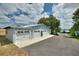Detached four-car garage with white doors, a private entrance, and an expansive paved driveway at 1395 S Lake Reedy Blvd, Frostproof, FL 33843