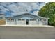 Four-car garage with carriage doors offering ample parking and storage on a paved driveway at 1395 S Lake Reedy Blvd, Frostproof, FL 33843