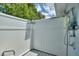 Outdoor shower area with a shower head, shower accessories, and a white privacy fence at 1395 S Lake Reedy Blvd, Frostproof, FL 33843