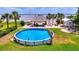 Waterfront property featuring above ground pool and covered outdoor kitchen at 1395 S Lake Reedy Blvd, Frostproof, FL 33843