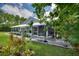 Exterior of the home shows a large, screened-in porch area with ample seating, leading to a landscaped backyard at 1395 S Lake Reedy Blvd, Frostproof, FL 33843