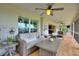 A charming screened porch has cozy wicker furniture and a ceiling fan for relaxing at 1395 S Lake Reedy Blvd, Frostproof, FL 33843