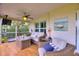The screened porch has ample seating, a ceiling fan, and stylish decor creating a cozy outdoor space at 1395 S Lake Reedy Blvd, Frostproof, FL 33843