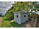A cute exterior view of the shed in the backyard with green grass, plants, and stepping stones at 1395 S Lake Reedy Blvd, Frostproof, FL 33843
