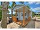 Charming shed with a covered porch and stone patio is surrounded by palms at 1395 S Lake Reedy Blvd, Frostproof, FL 33843
