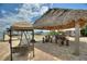Waterfront tiki hut with a bar, swing and paver patio is perfect for outdoor entertaining at 1395 S Lake Reedy Blvd, Frostproof, FL 33843