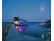 Scenic nighttime view of a dock with boat lifts, slide, and tiki hut at 1395 S Lake Reedy Blvd, Frostproof, FL 33843
