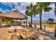 A waterfront view featuring tiki hut, lounge chairs, and palm trees at 1395 S Lake Reedy Blvd, Frostproof, FL 33843