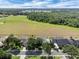 A high angle view of backyard spaces featuring mature trees, screened patios, and fence lines of multiple properties at 2161 Longleaf Cir, Lakeland, FL 33810