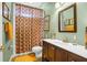Traditional bathroom with a colorful shower curtain, hardwood vanity, modern faucet, and framed mirror at 2161 Longleaf Cir, Lakeland, FL 33810