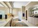Bright bathroom features a double sink vanity, a soaking tub, and a glass door shower, complemented by tiled floors and cabinets at 2161 Longleaf Cir, Lakeland, FL 33810