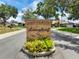 Landscaped Longleaf community entrance with brick signage and lush plants under blue skies at 2161 Longleaf Cir, Lakeland, FL 33810