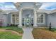 Elegant front entrance with stately columns, a charming water feature, and a beautifully designed blue front door at 2161 Longleaf Cir, Lakeland, FL 33810