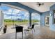Relaxing screened-in lanai featuring a stone floor, ceiling fan, and view of the beautiful backyard and pool at 2161 Longleaf Cir, Lakeland, FL 33810