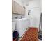 Functional laundry room with washer, dryer, cabinets, utility sink, and decorative floor runner at 2161 Longleaf Cir, Lakeland, FL 33810