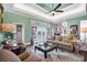 Inviting living room with tray ceilings, ceiling fan, French doors to lanai, and comfortable striped seating at 2161 Longleaf Cir, Lakeland, FL 33810