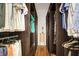 Spacious walk-in closet features dark wood built-ins, with shelving and rods on both sides and a hardwood floor at 2161 Longleaf Cir, Lakeland, FL 33810