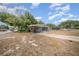 View of home showing long driveway, covered carport and small screened porch at 129 5Th Jpv St, Winter Haven, FL 33880