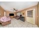 A comfy living room featuring tan walls, tile flooring, ceiling fan and large windows at 129 5Th Jpv St, Winter Haven, FL 33880