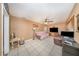 Living room with tan walls, tile flooring, ceiling fan and large windows at 129 5Th Jpv St, Winter Haven, FL 33880